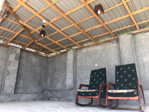 two chairs sitting in a room with a ceiling at Qebele Vendam in Gabala