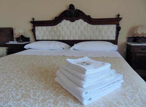 a neatly made bed with white sheets and pillows at Villa Sara in Taormina