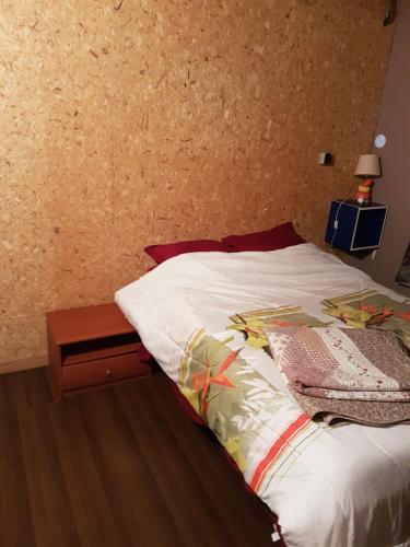 - une chambre avec un lit et une table de chevet en bois dans l'établissement le belair, à Carosse