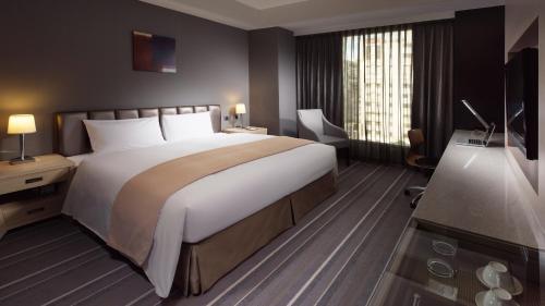 a hotel room with a large bed and a window at Urban Hotel33 in Kaohsiung