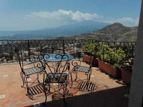uma mesa e cadeiras numa varanda com vista em Villa Sara em Taormina
