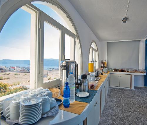 uma cozinha com um balcão com pratos e pratos em Thira's Dolphin em Acrotíri