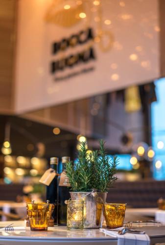 a table with a potted plant and bottles of wine at Radisson Hotel Zurich Airport in Rümlang