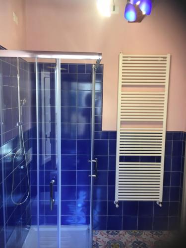 a bathroom with a shower with blue tiles at Vicolo del Geppone in Lucca