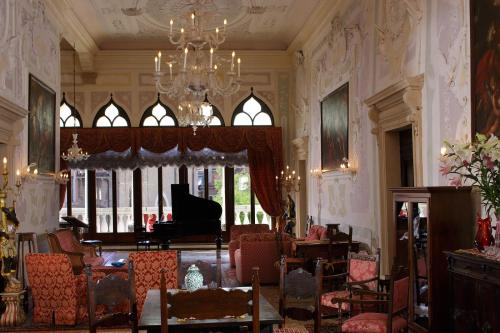 a living room with a chandelier and a piano at Hotel La Residenza in Venice