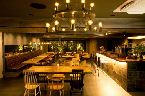 a restaurant with tables and chairs and a chandelier at Hotel Banister Kyoto in Kyoto
