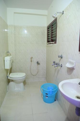 a bathroom with a toilet and a sink at Hotel Garuda Guntur in Guntūr
