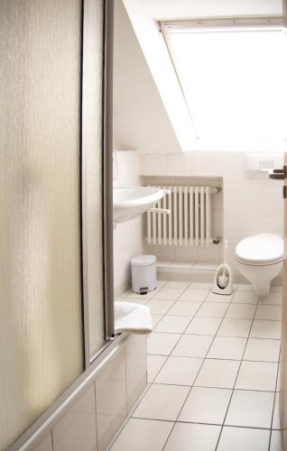 a bathroom with a toilet and a sink at Hotel Restaurant Genusshaus Vorst in Tönisvorst