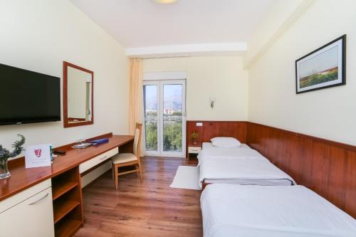 Habitación hospitalaria con 2 camas y escritorio en Hotel Merlot en Opuzen