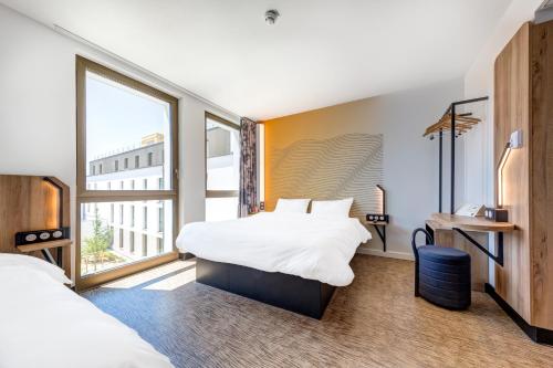 Habitación de hotel con 2 camas y ventana en B&B HOTEL Paris Sud Chatenay Malabry en Châtenay-Malabry