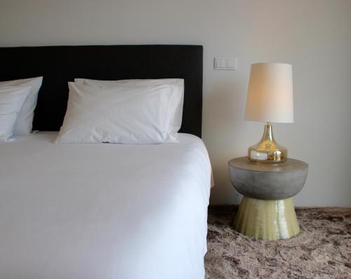 a bedroom with a bed and a table with a lamp at Quinta Tagus in Costa da Caparica