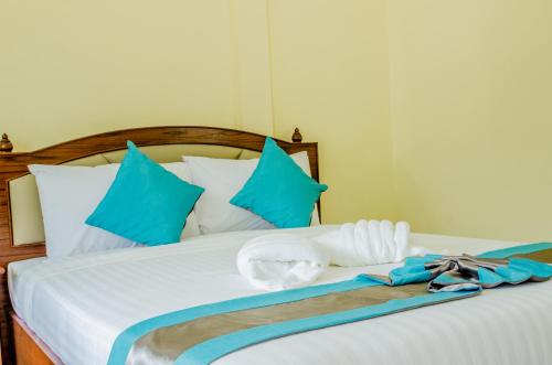 uma cama com almofadas azuis e brancas e uma toalha em Changsi Resort-Krabi em Krabi