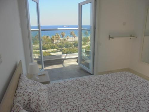 Schlafzimmer mit einem Bett und Meerblick in der Unterkunft Kermia Court - Beach-front, modern 2 bedroom -sleeps 6 in Limassol
