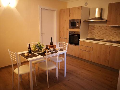 - une cuisine avec une table et des chaises blanches dans la chambre dans l'établissement Domus Praetoria cir 0166, à Aoste