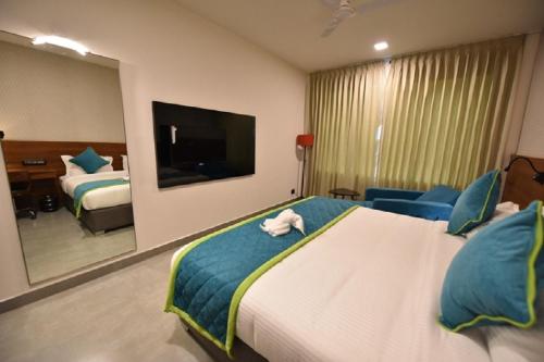 a hotel room with a large bed and a mirror at Vivid A Boutique Hotel in Tiruchchirāppalli