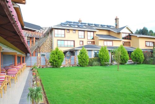 a large house with a lawn in front of it at Misty Mountain Lodge in Naro Moru
