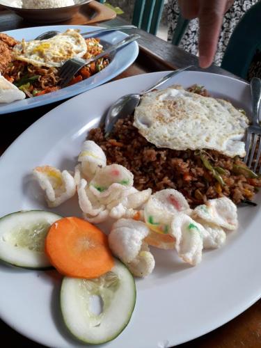 a plate of food with eggs and rice and vegetables at Rinjani Houseboon in Senaru