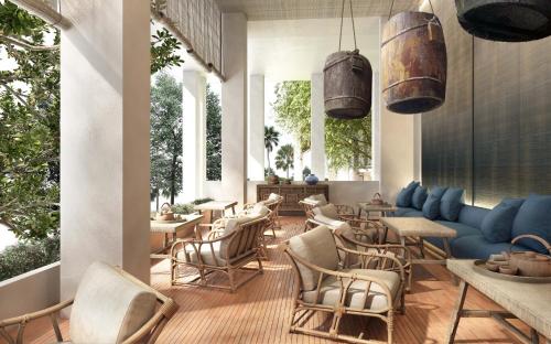 a restaurant with chairs and a blue couch and tables at Raya Heritage - SHA Plus in Chiang Mai