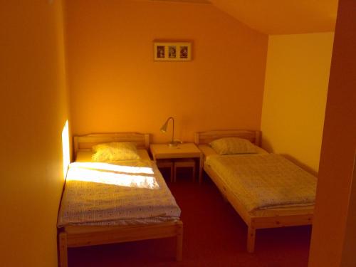 a small room with two beds and a table at Penzion Cihelna in Brno