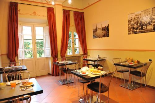 a restaurant with tables and chairs in a room at B&B Il Seminario in Lucca