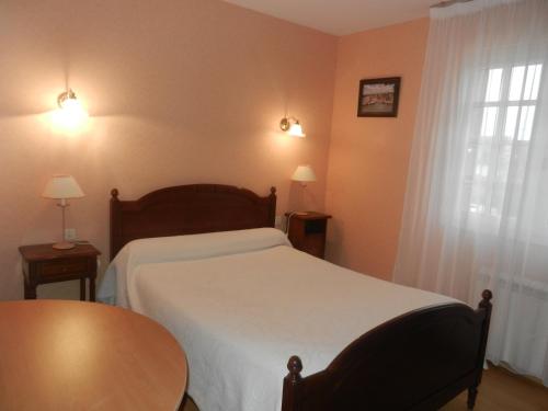 サンタンヌ・ドーレーにあるLe Clos Des Alouettesのベッドルーム1室(ベッド1台、テーブル、窓付)