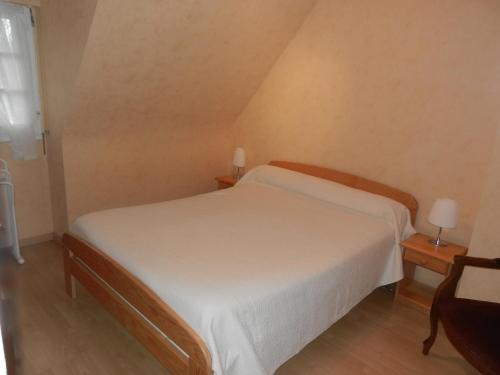 1 dormitorio con 1 cama blanca y 2 mesitas de noche en Le Clos Des Alouettes, en Sainte-Anne-d'Auray