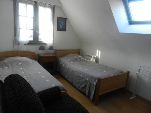 une chambre avec deux lits et deux fenêtres dans l'établissement Le Clos Des Alouettes, à Sainte-Anne-d'Auray