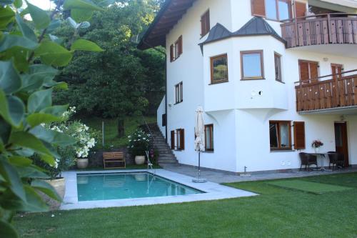 a house with a swimming pool in the yard at Villa Falkner in Tirolo