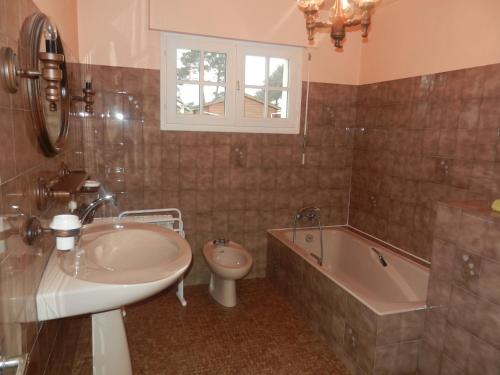 een badkamer met een wastafel, een bad en een toilet bij Le Clos Des Alouettes in Sainte Anne d'Auray 