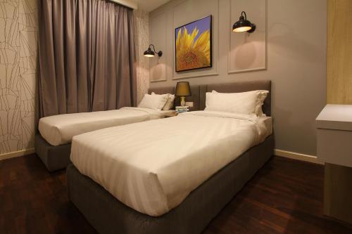 2 Betten in einem Hotelzimmer mit weißer Bettwäsche in der Unterkunft The Shore Residence Apartment in Malakka