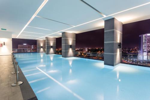 einem Pool in einem Gebäude mit Skyline der Stadt in der Unterkunft The Shore Residence Apartment in Malakka