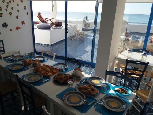 un tavolo con cibo sopra con vista sull'oceano di B&B Mammaliturchi SCALA DEI TURCHI a Realmonte