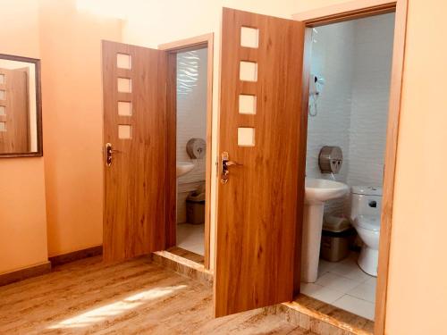 a bathroom with two doors and a toilet at Danista Nomads Tour Hostel in Ulaanbaatar