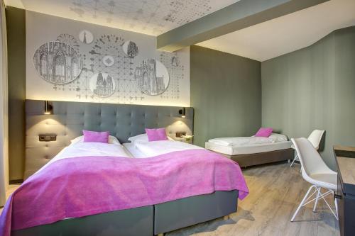 a bedroom with two beds with pink sheets at Boutique 003 Köln City am Dom, Trademark Collection by Wyndham in Cologne
