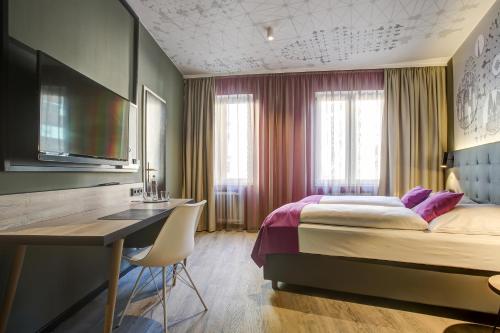 a hotel room with a bed and a desk and a desk at Boutique 003 Köln City am Dom, Trademark Collection by Wyndham in Cologne