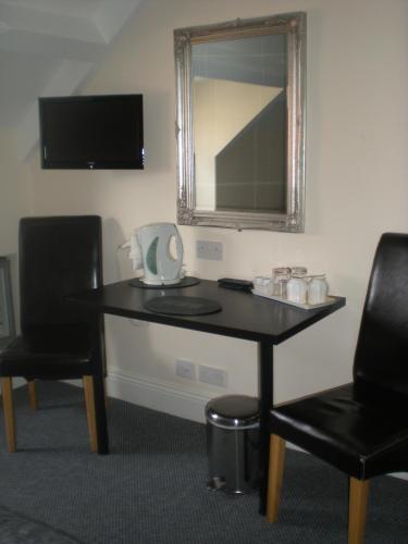 a table with two chairs and a mirror in a room at Elmswood Guest House in South Shields