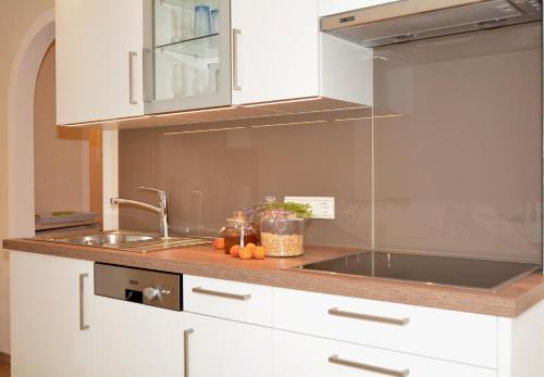a kitchen with white cabinets and a sink at Landhaus Notburga in Gries im Sellrain