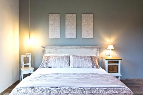 a bedroom with a large white bed with two lamps at Nonna Giulina in Castagnole Lanze