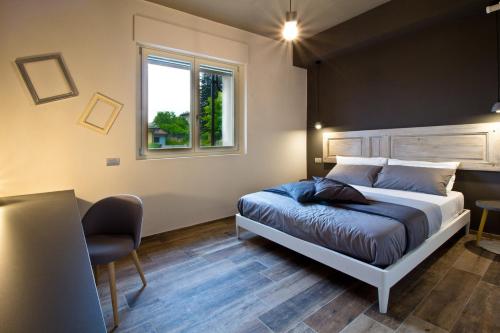 a bedroom with a bed and a desk and a window at Nonna Giulina in Castagnole Lanze