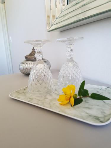 a tray with two glassases and a yellow flower on it at Domaine de la Fauvriere in Sainte-Honorine-de-Ducy