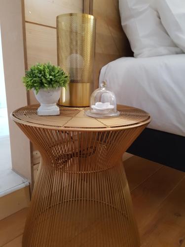 a wicker table with a vase and a lamp on it at Domaine de la Fauvriere in Sainte-Honorine-de-Ducy