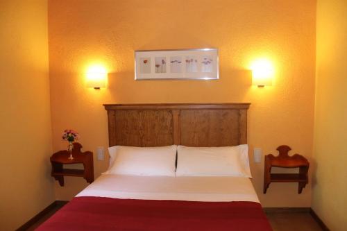 1 dormitorio con 1 cama con 2 luces en la pared en Apartaments La Taverna dels Noguers, en El Pont de Bar