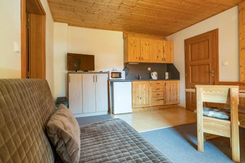 a living room with a couch and a kitchen at S4 Resort Kouty in Loučná nad Desnou
