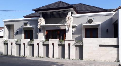 a white house with a fence in front of it at Imperial Villa Syariah in Yogyakarta