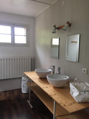 - une salle de bains avec deux lavabos sur un comptoir en bois dans l'établissement Gites les Grandes Gouttes, à Le Syndicat