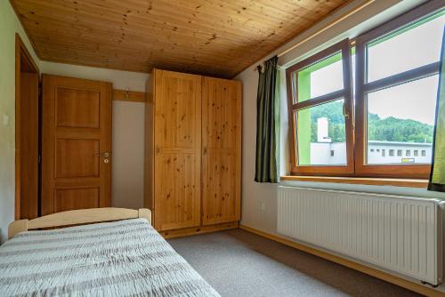 a bedroom with a bed and a window at S4 Resort Kouty in Loučná nad Desnou