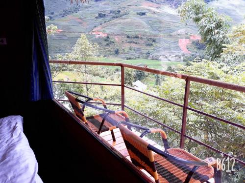 a room with two chairs on a balcony with a view at Eco Hills Homestay in Sa Pa