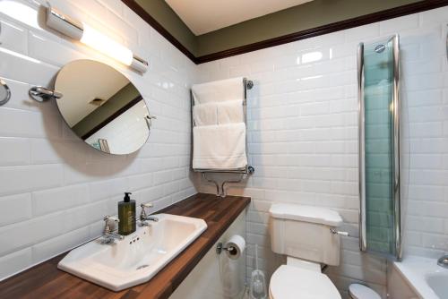 a bathroom with a sink and a toilet and a mirror at Cairn Hotel in Harrogate