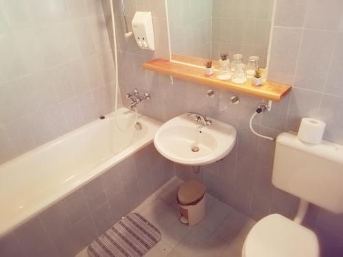 ein Badezimmer mit einem Waschbecken, einem WC und einer Badewanne in der Unterkunft Guest House Turistična kmetija Plaznik in Ljubno