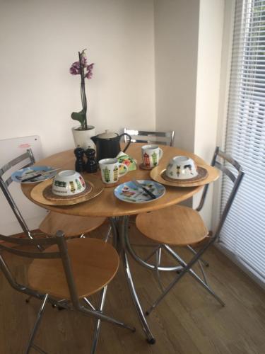 a table with two chairs and a table with dishes on it at Hillcrest House Self Catering Apartments in Donegal